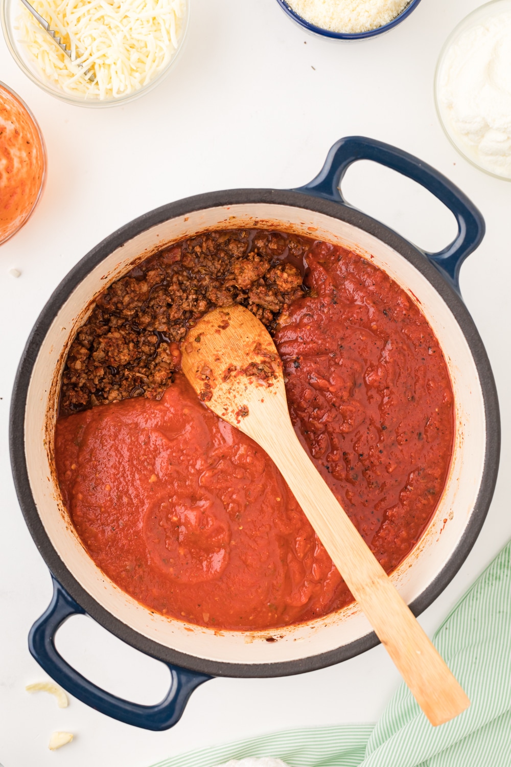 tomatoes, fire-roasted canned tomatoes, and meat sauce for lasagna in a dutch oven