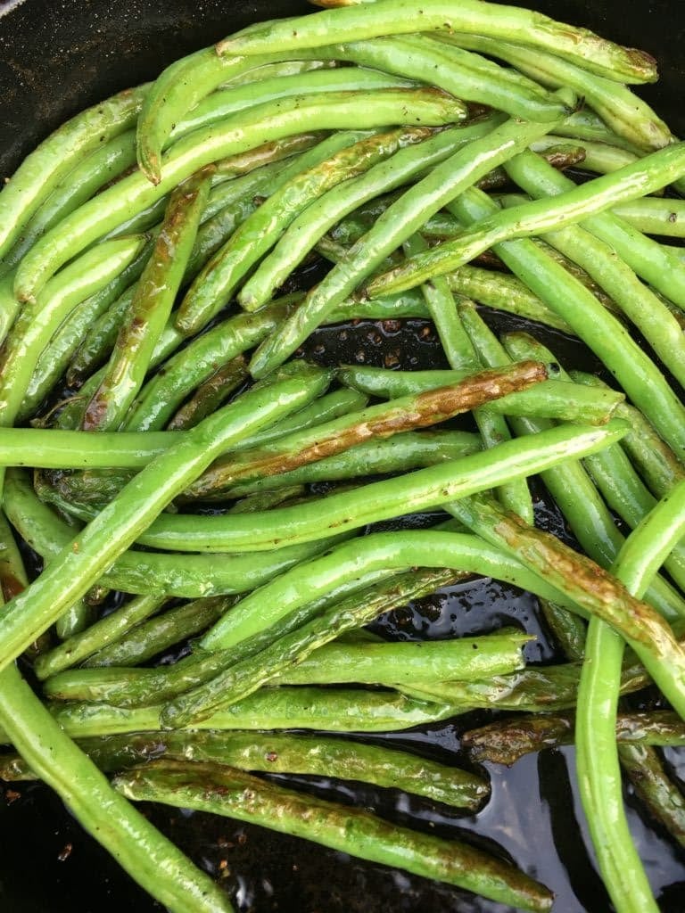 blistered green beans in a skillet