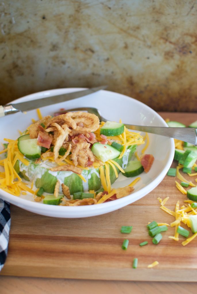 Classic wedge salad using Ina Garten's method of cutting into a disc. This salad is filled with cheese, bacon, fried onions, and ranch dressing.