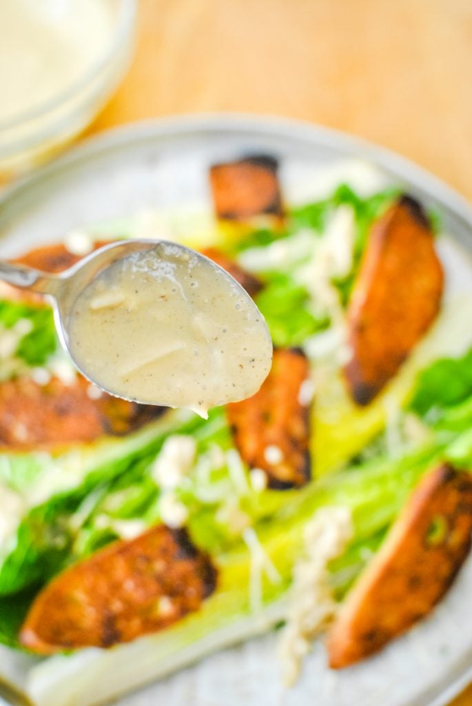 Drizzling Caesar Dressing on Salad