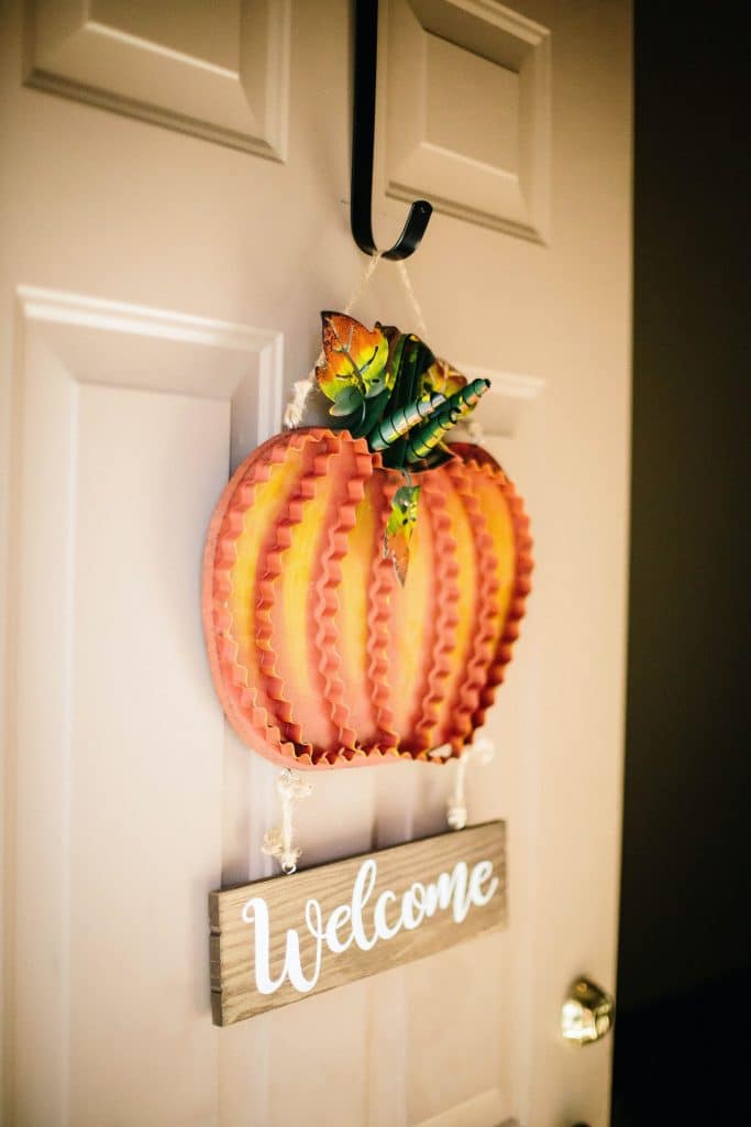 welcoming front door with a pumpkin