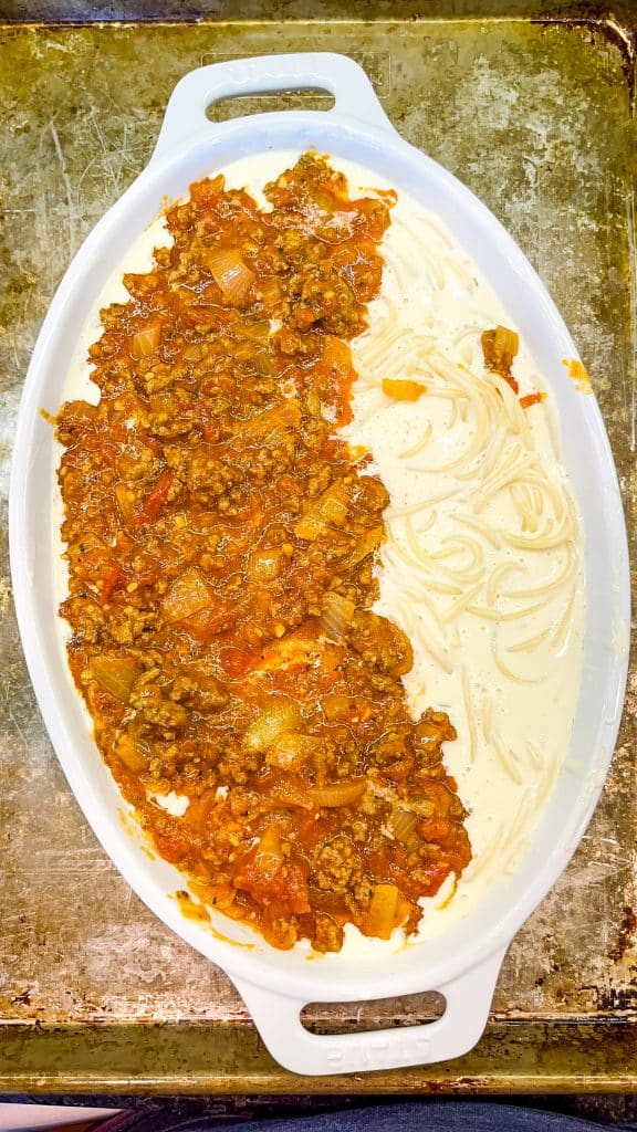 alfredo spagehtti with meat sauce on top