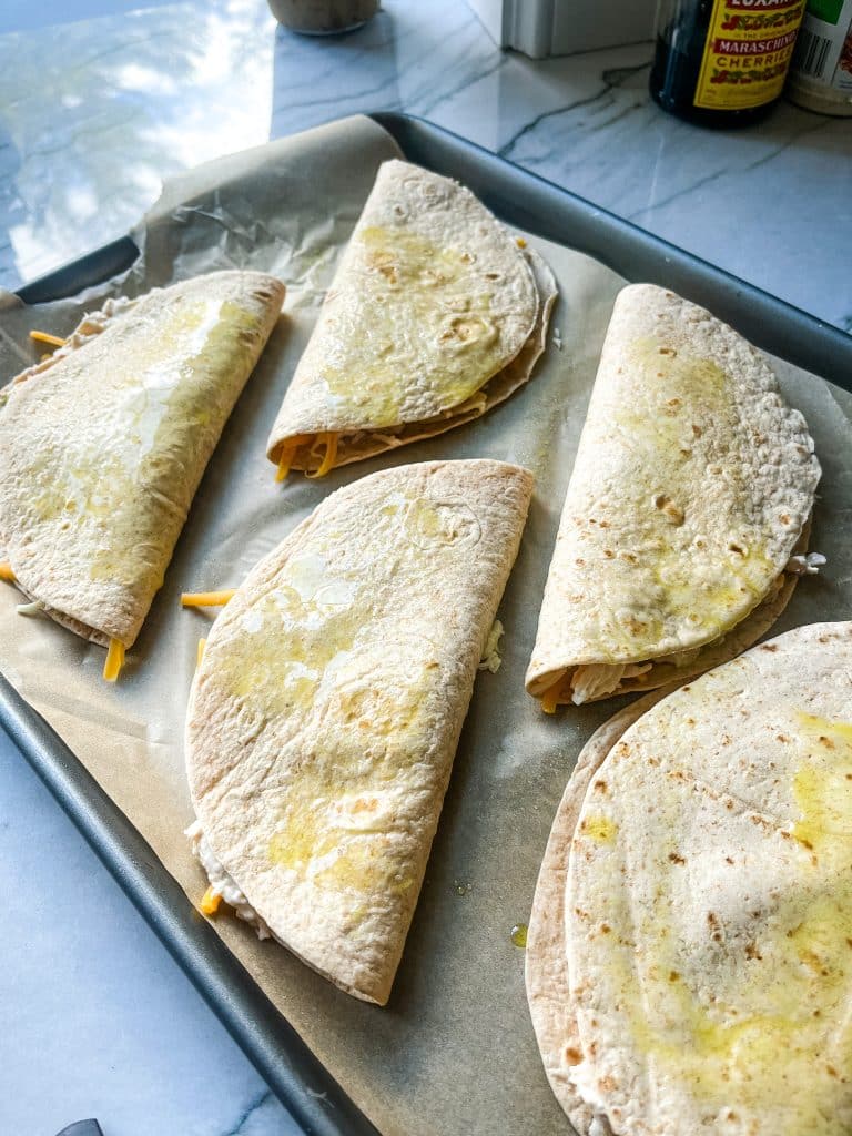 unbaked chicken quesadillas on a sheet pan