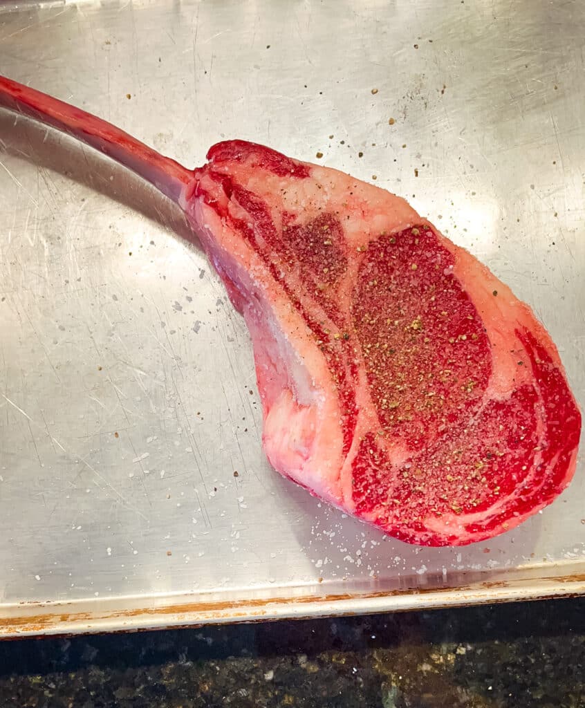seasoning both sides of a bone-in ribeye steak