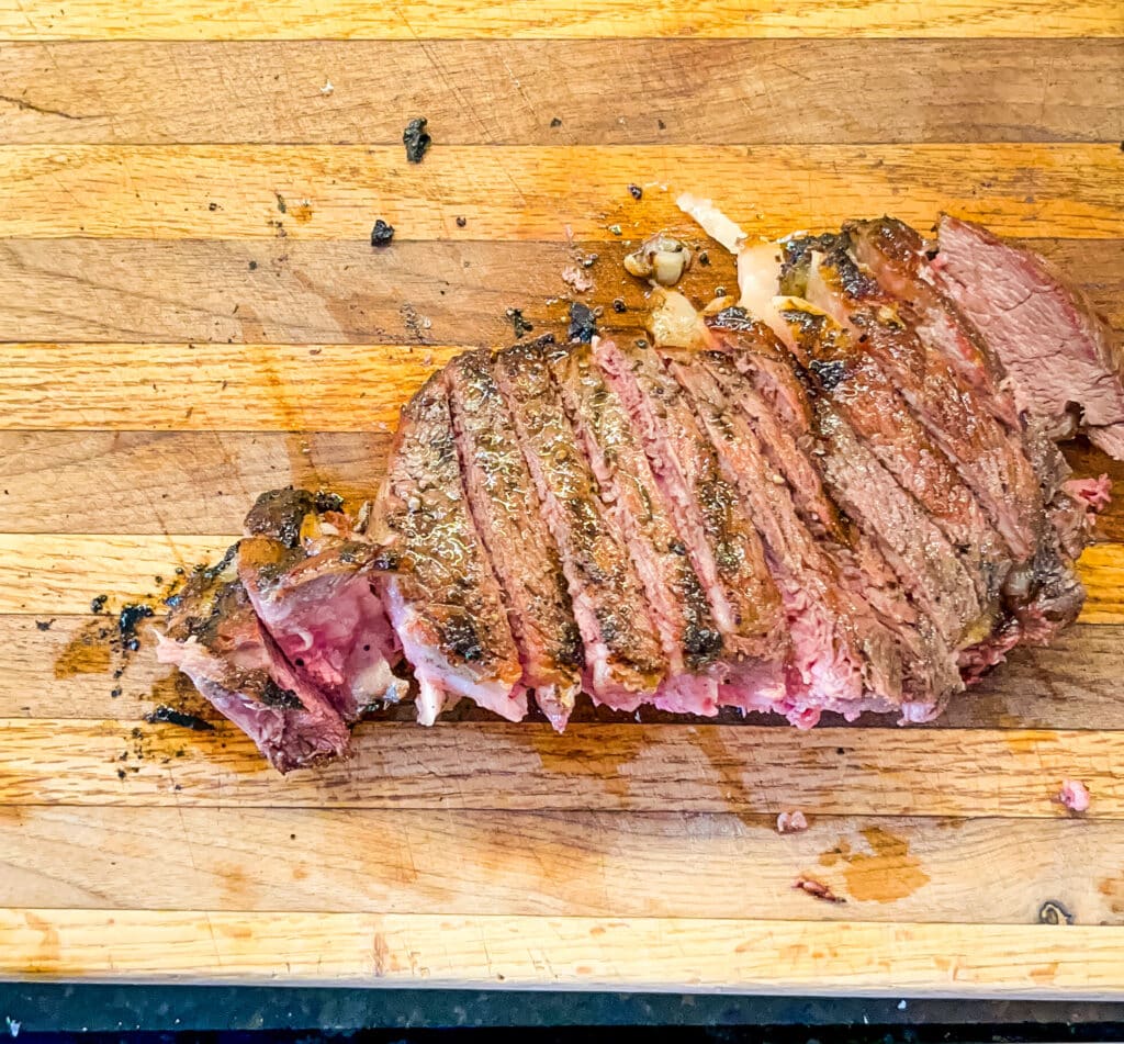 sliced tomahwak steak on a cutting board