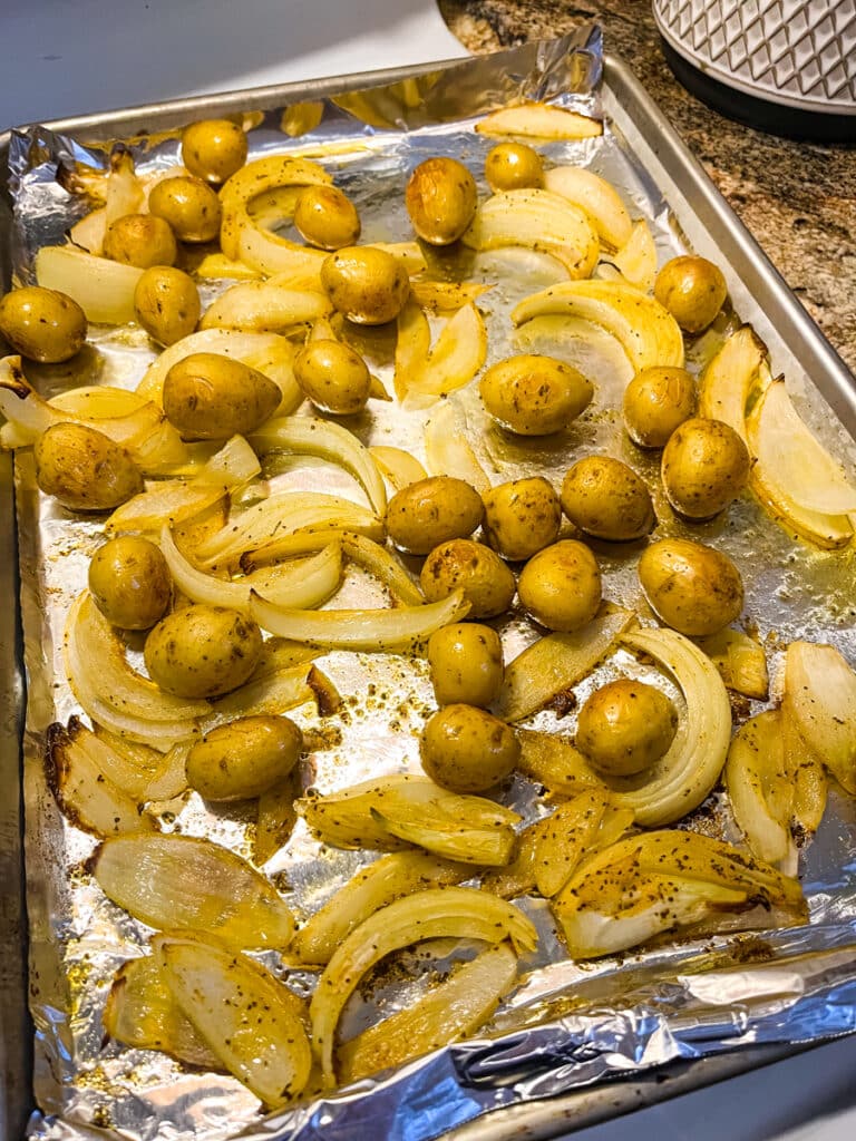 roasted potatoes and onions on a sheet pan