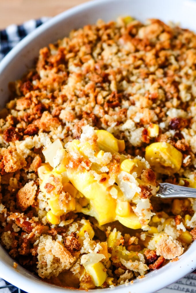 Cheesy Sunshine Casserole made with yellow squash, corn, and a crunchy stuffing topping baked until golden brown.