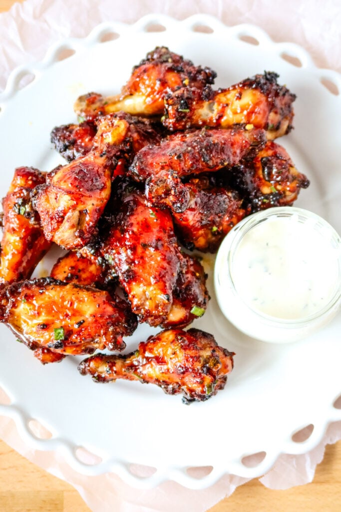 Air fryer chicken wings with honey butter glaze served on a white platter with ranch.