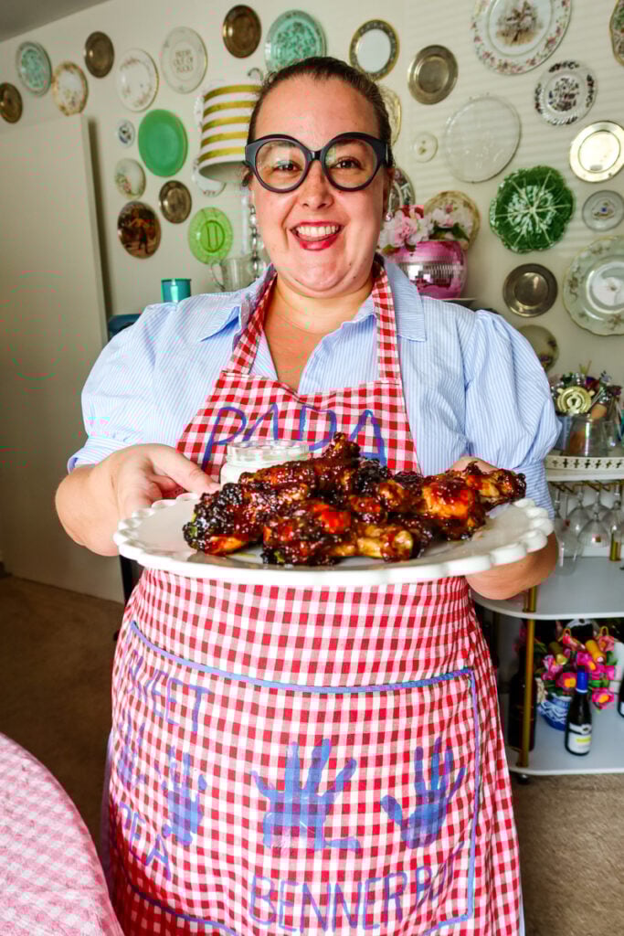 Hostess presenting a plate of honey hot chicken wings made in the air fryer.