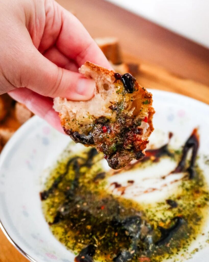 Italian bread dip with herbs and olive oil, served with fresh bread for a game day appetizer.