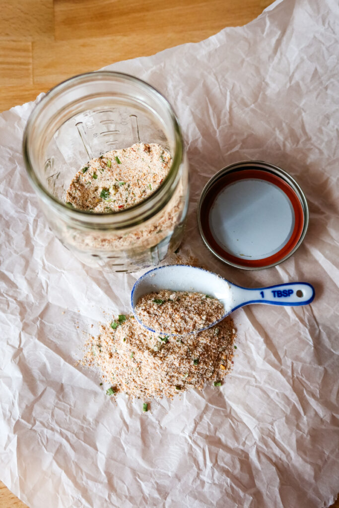 Overhead shot of glass jar and measuring spoon with Firecracker Seasoning Blend.