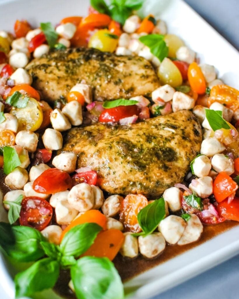 Pesto chicken breast served with fresh caprese salad of tomatoes, mozzarella, and basil