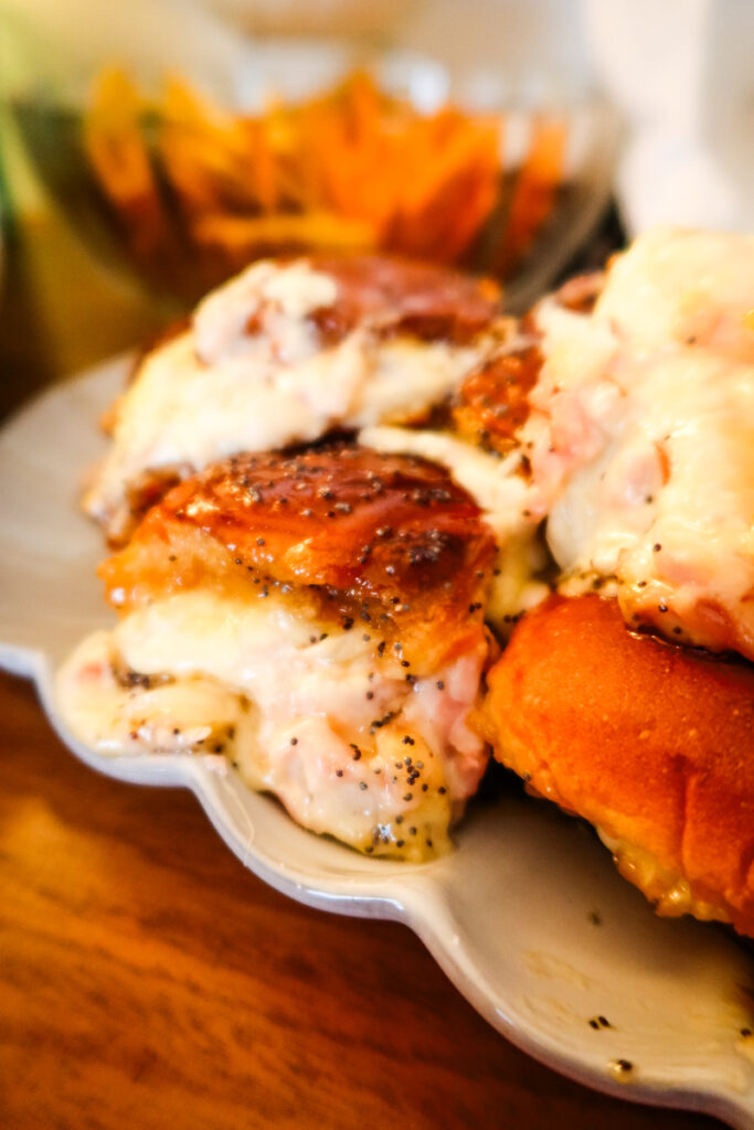 Swiss Onion Dip Sliders with Ham on Hawaiian rolls, golden brown and cheesy, served on a platter.
