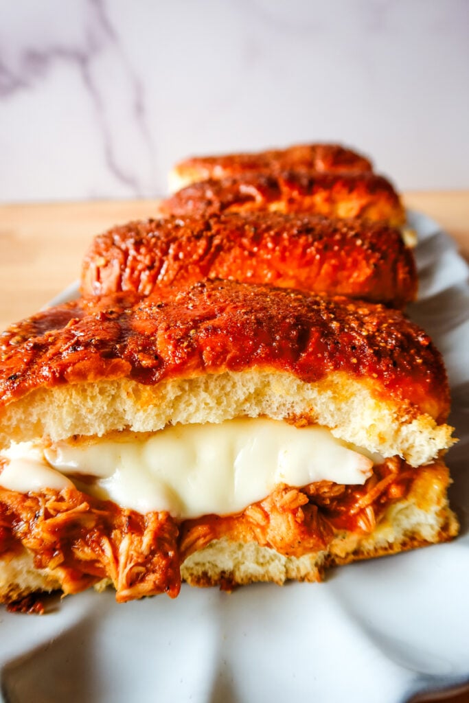 Close-up of cheesy BBQ chicken sub slider baked on King’s Hawaiian roll with honey butter glaze.