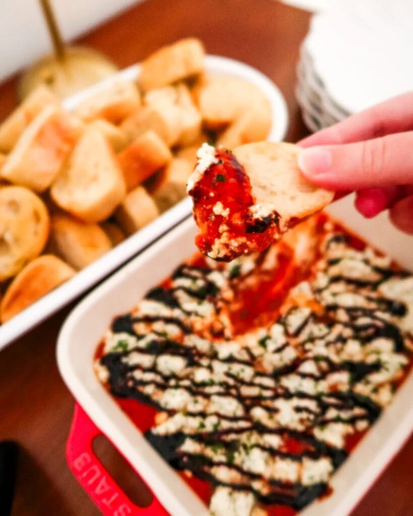 Small bowl of marinara dip swirled with Boursin cheese.
