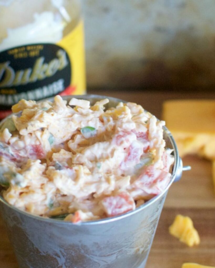 Bowl of creamy pimento cheese served with crackers.