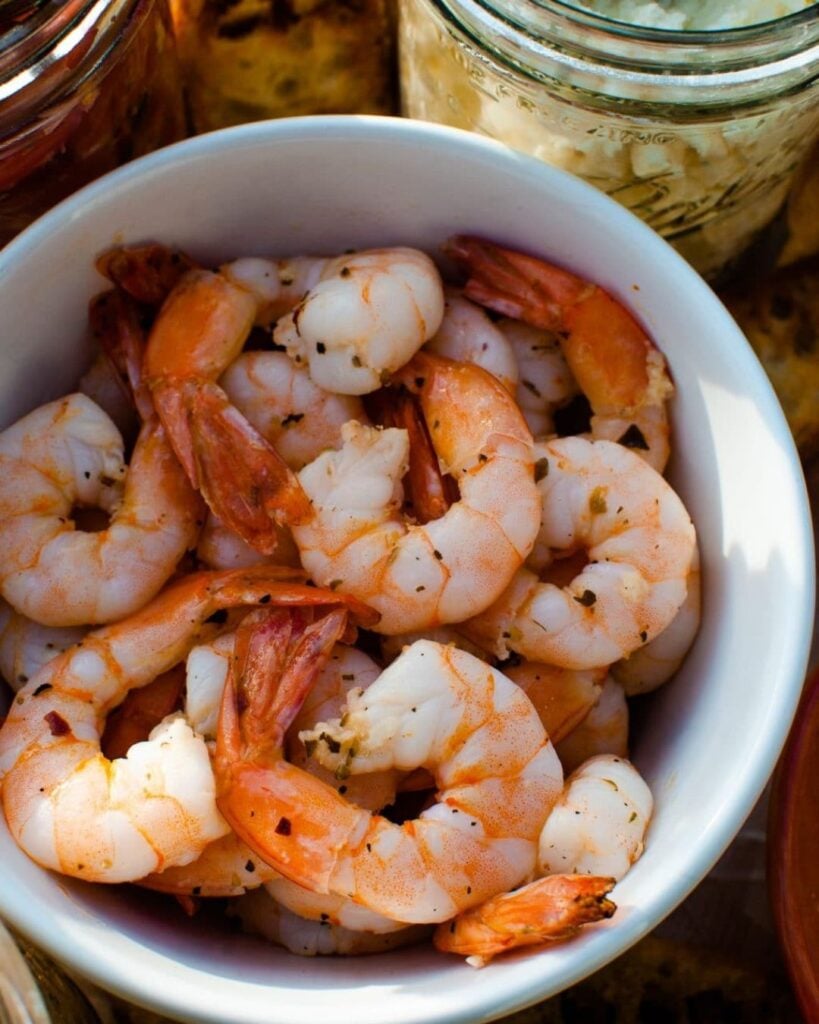 Platter of roasted shrimp with cocktail sauce for a party appetizer.