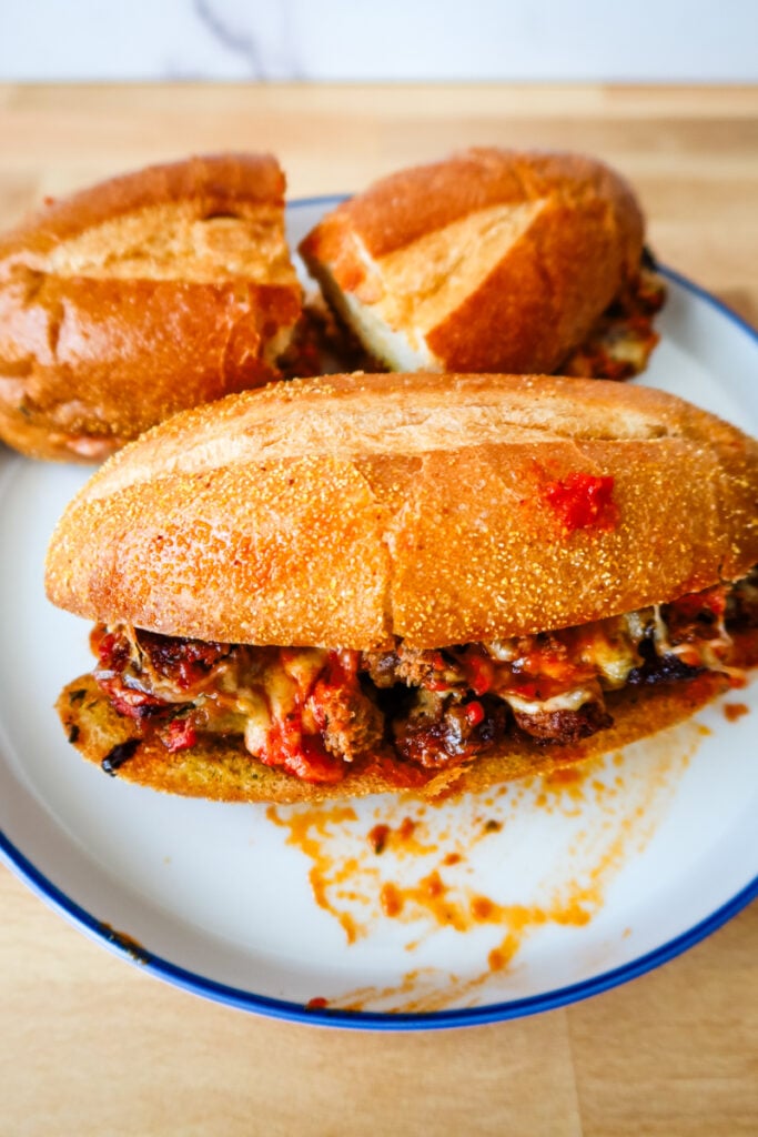 Plate stacked with smashed meatball subs ready to serve.