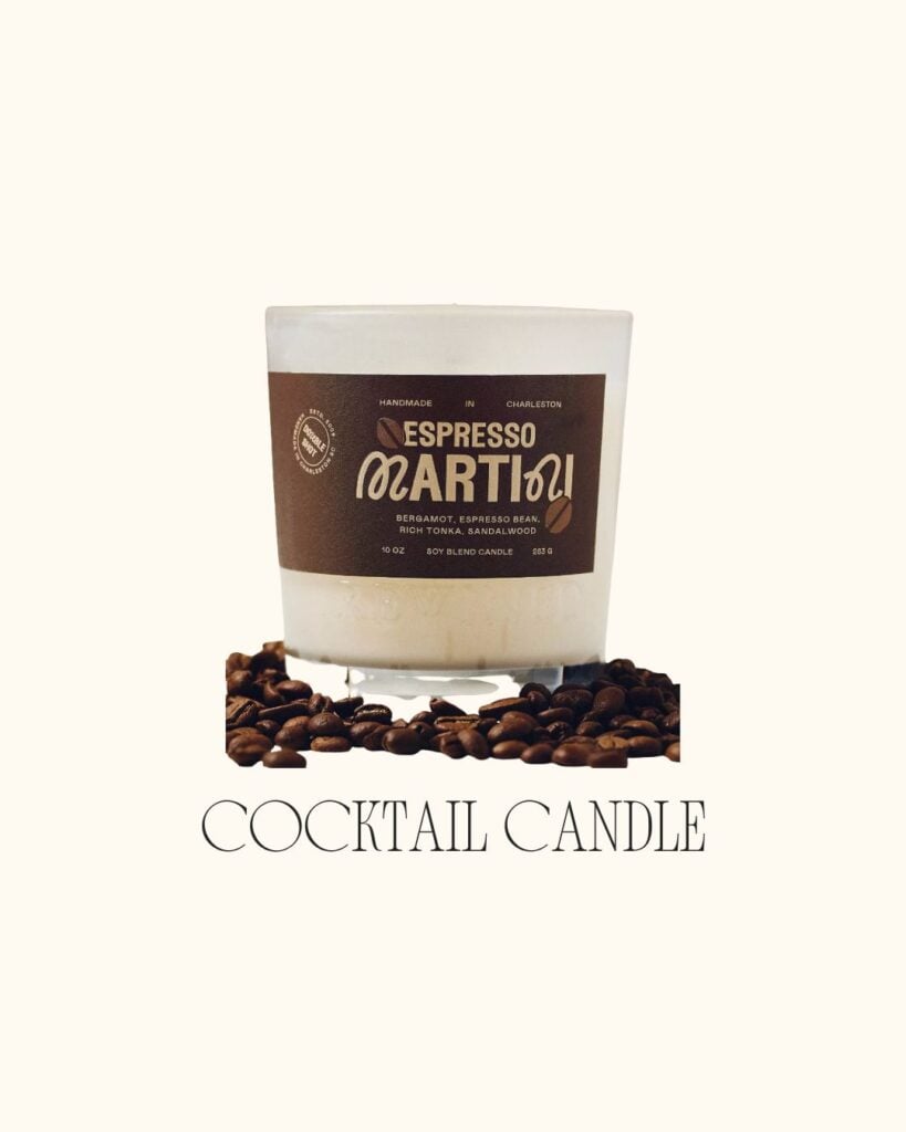 Espresso martini–scented candle surrounded by coffee beans on a cream background.