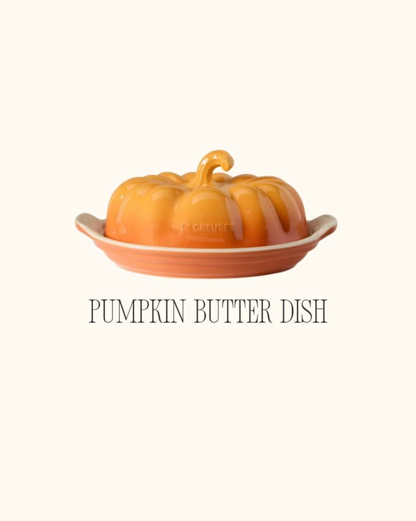 Orange pumpkin-shaped ceramic butter dish with lid, displayed on a cream background.