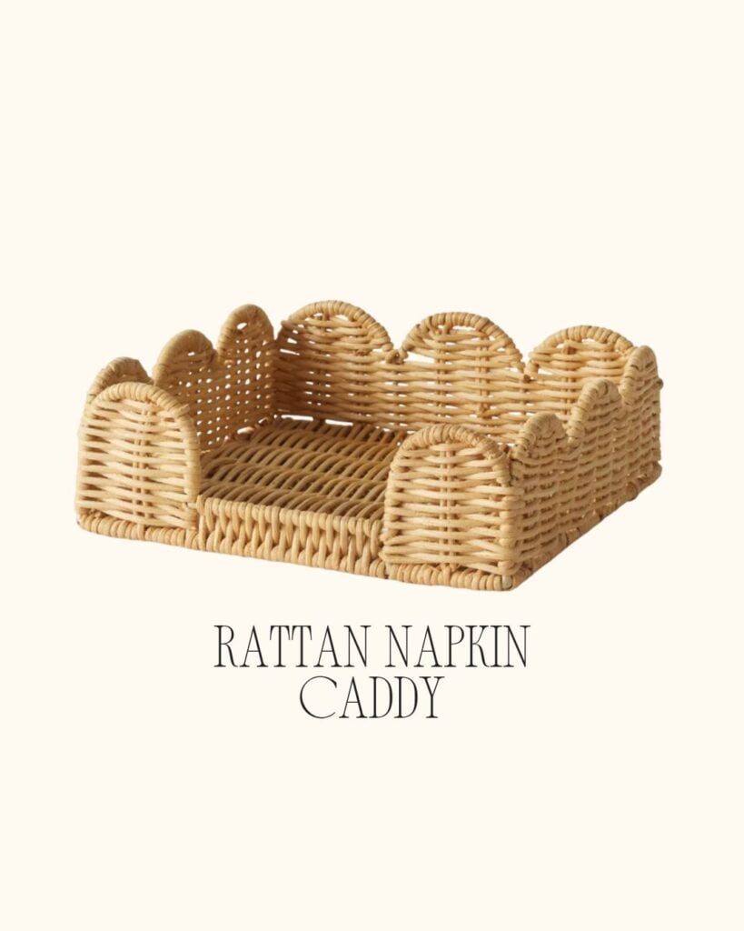 A woven rattan napkin caddy with scalloped edges, styled against a light cream background.