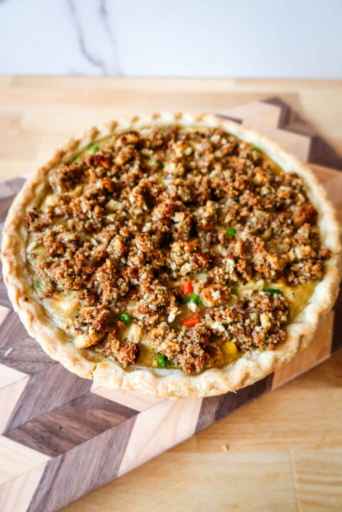 freshly baked chicken pot pie with golden brown stuffing topping on a wooden board