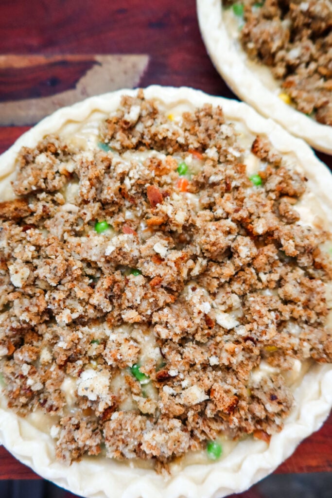 unbaked chicken pot pie topped with stuffing in a pie crust ready to go in the oven
