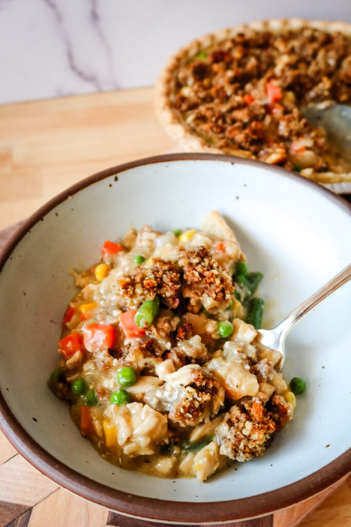 serving of creamy chicken pot pie with vegetables and stuffing topping in a bowl with a spoon
