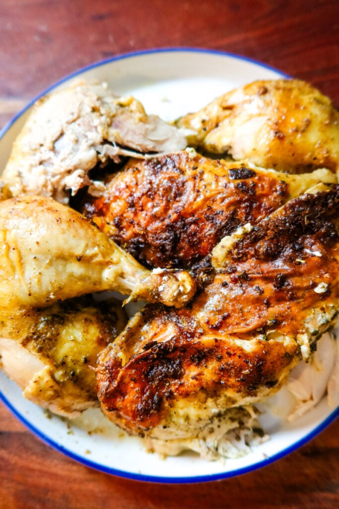 Carved Thanksgiving Butternaise Chicken on a serving platter with golden skin and herbs.