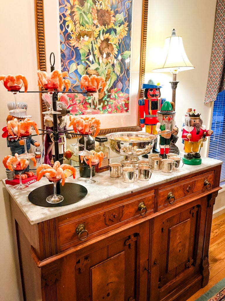 Christmas cocktail bar with nutcrackers, shrimp cocktail glasses, silver punch bowl, and holiday decor