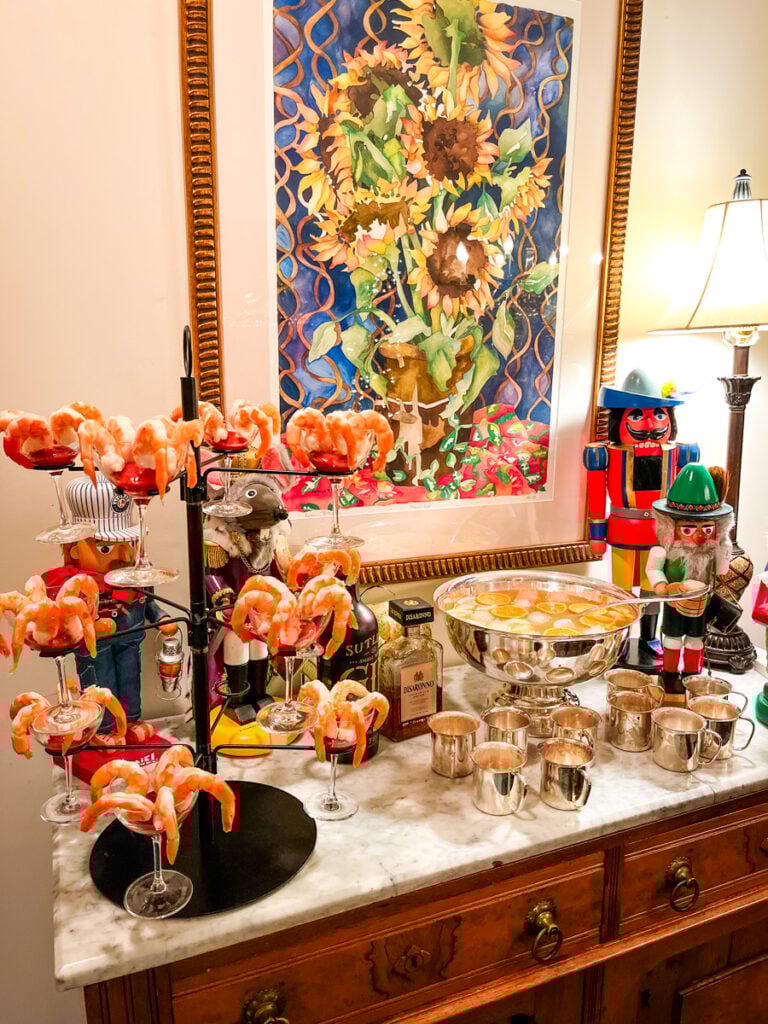 Jingle Juice punch in a silver bowl with silver mugs ready for a Christmas cocktail party