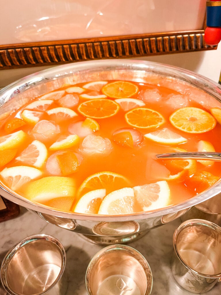Overhead view of Jingle Juice punch with orange slices, lemon wedges, and ice floating in a large bowl