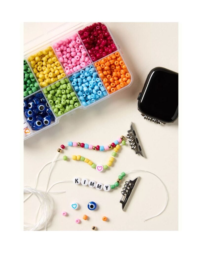 DIY beaded Apple Watch band kit with colorful beads arranged on a neutral surface