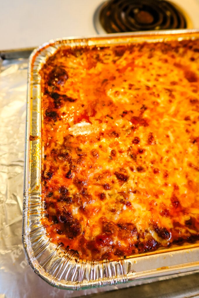 Overhead view of Sweetpea’s New Lasagna baked in a large foil pan with golden melted cheese