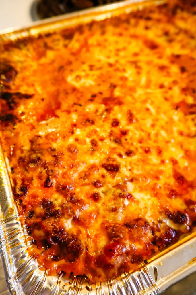 Side angle of Sweetpea’s New Lasagna showing golden cheese and rich tomato sauce layers