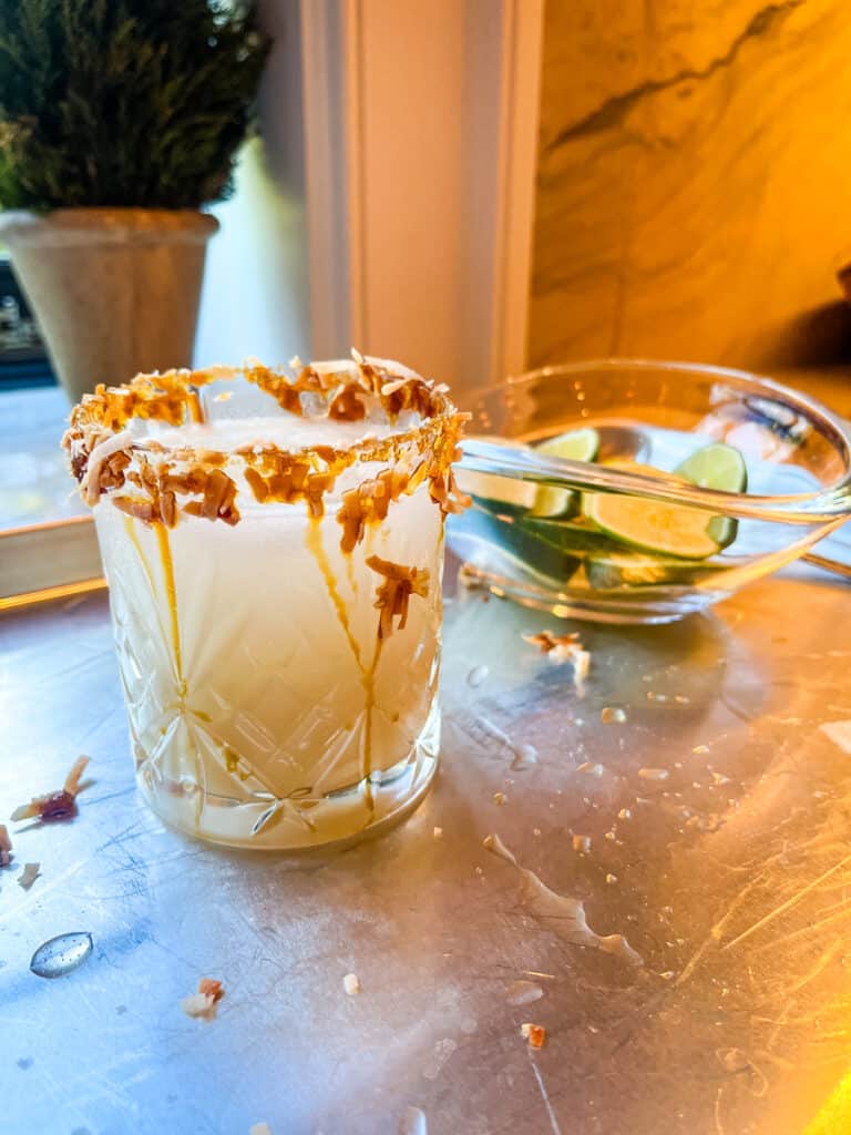 Pina colada margarita cocktail with toasted coconut rim in rocks glass