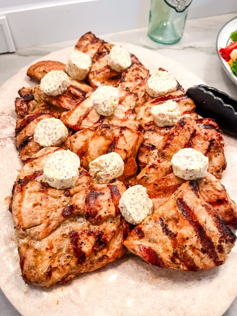 Grilled steakhouse marinated chicken with herb butter on serving platter