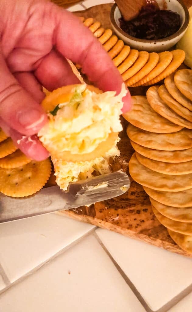 A cracker topped with creamy Green Onion Cheeseball spread, showing the cheesy texture of this classic Southern appetizer recipe.