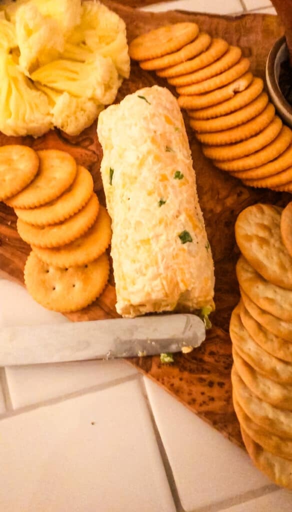 Creamy Green Onion Cheeseball served on a wooden appetizer board with Ritz crackers and pineapple for an easy Southern party appetizer.